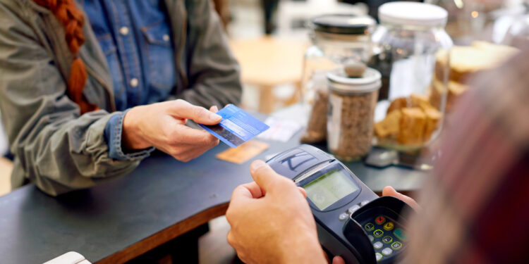 Shot of a customer paying for their order with a credit card machine in a cafe